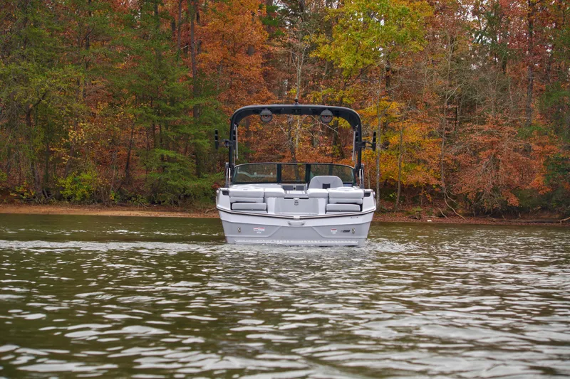  Yacht Photos Pics 2025 MasterCraft XT23 boat on a lake with autumn foliage background.