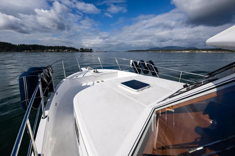  Yacht Photos Pics Symbol 42 Classic Trawler 2000 cruising on calm waters under a partly cloudy sky.