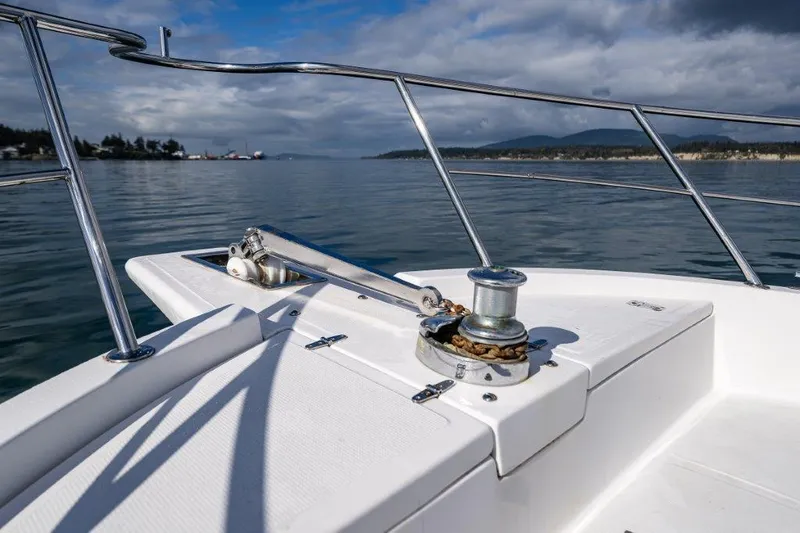  Yacht Photos Pics Bow of 2000 Symbol 42 Classic Trawler on calm water, featuring anchor winch.