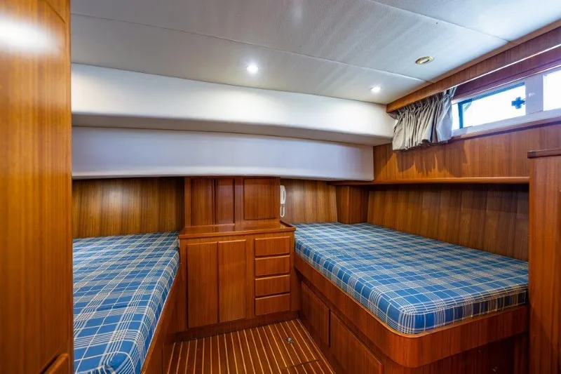  Yacht Photos Pics Cozy cabin interior of 2000 Symbol 42 Classic Trawler with twin beds and wood paneling.