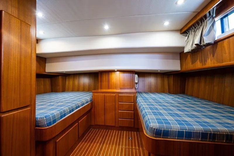  Yacht Photos Pics Cozy cabin interior of 2000 Symbol 42 Classic Trawler with twin beds and wood paneling.