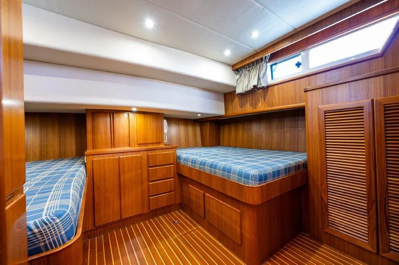  Yacht Photos Pics Cozy cabin interior of 2000 Symbol 42 Classic Trawler with twin beds and wooden finish.