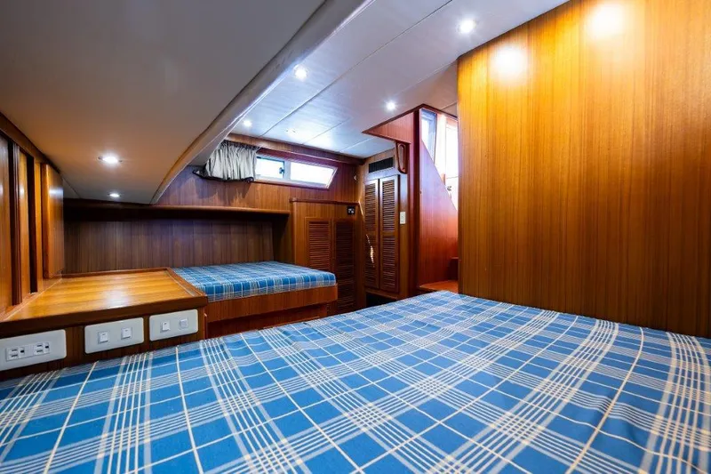  Yacht Photos Pics Interior of 2000 Symbol 42 Classic Trawler with wood paneling and blue plaid bedding.