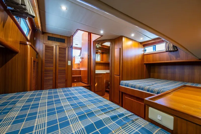  Yacht Photos Pics Cozy cabin interior of 2000 Symbol 42 Classic Trawler with wood paneling and twin beds.