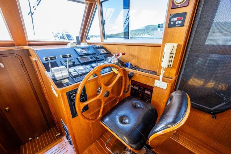  Yacht Photos Pics Symbol 42 Classic Trawler 2000 helm with wooden wheel and navigation controls.