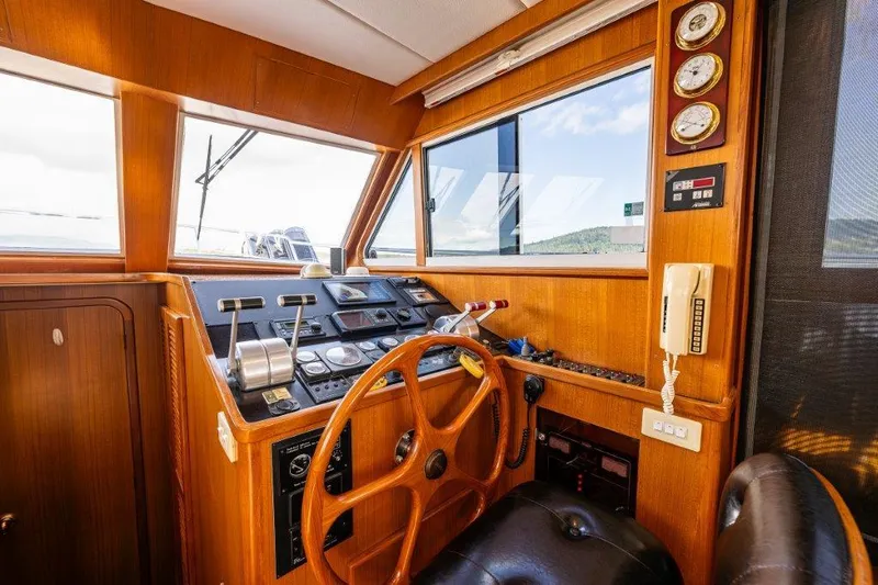  Yacht Photos Pics Interior helm of 2000 Symbol 42 Classic Trawler with wooden steering wheel and navigation instruments.