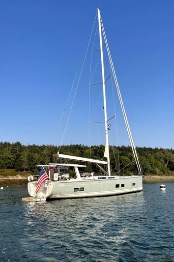  Yacht Photos Pics 2019 Hanse 588 yacht anchored in calm waters under clear blue sky.