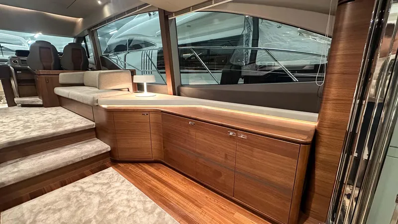 F55163 Yacht Photos Pics Luxurious interior of 2023 Princess F55 yacht with elegant wood finishes and plush seating.