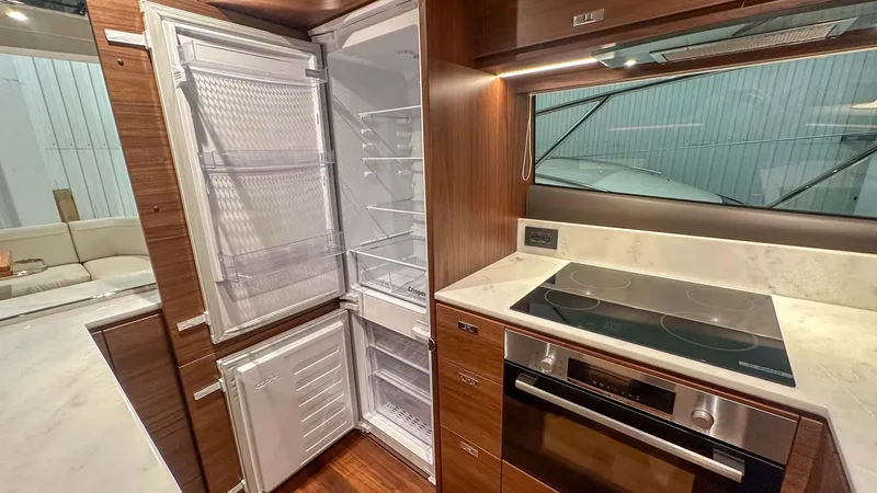 F55163 Yacht Photos Pics Modern kitchen in 2023 Princess F55 yacht with open fridge and sleek appliances.