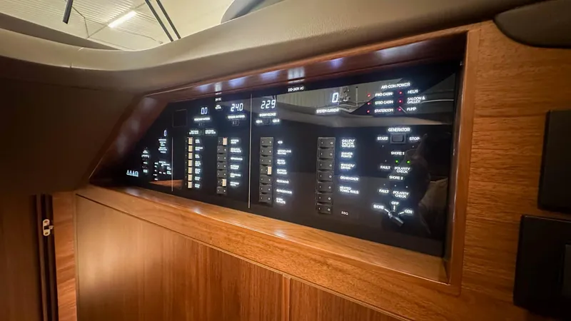 F55163 Yacht Photos Pics Control panel of 2023 Princess F55 yacht with illuminated displays and wooden finish.