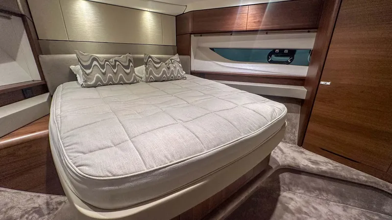F55163 Yacht Photos Pics Luxurious bedroom interior of 2023 Princess F55 yacht with elegant bedding and wood accents.