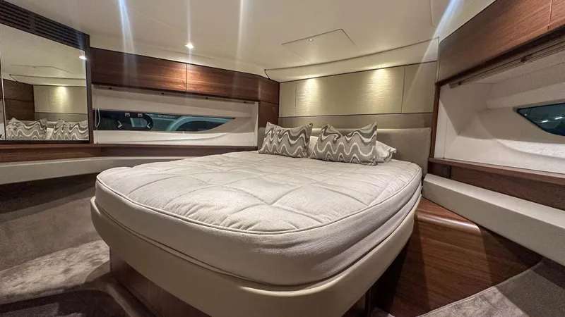 F55163 Yacht Photos Pics Luxurious cabin interior of 2023 Princess F55 yacht with elegant bedding and wood accents.