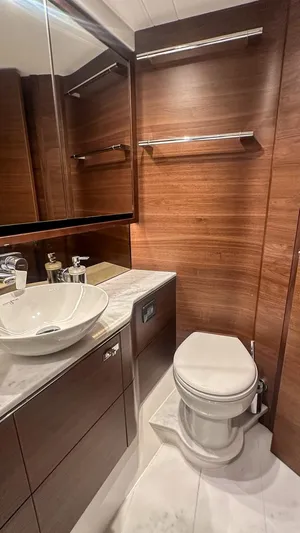 F55163 Yacht Photos Pics Luxurious bathroom in 2023 Princess F55 yacht with wood paneling and modern fixtures.