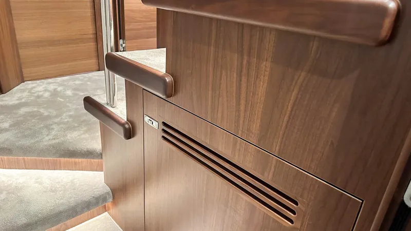 F55163 Yacht Photos Pics Luxurious interior of 2023 Princess F55 yacht with wooden finish and carpeted stairs.