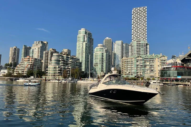  Yacht Photos Pics 2013 Sea Ray 330 Sundancer yacht cruising in urban waterfront with modern skyscrapers.