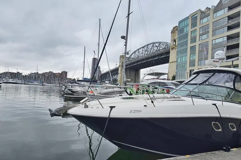  Yacht Photos Pics 2013 Sea Ray 330 Sundancer docked near a bridge in a marina setting.