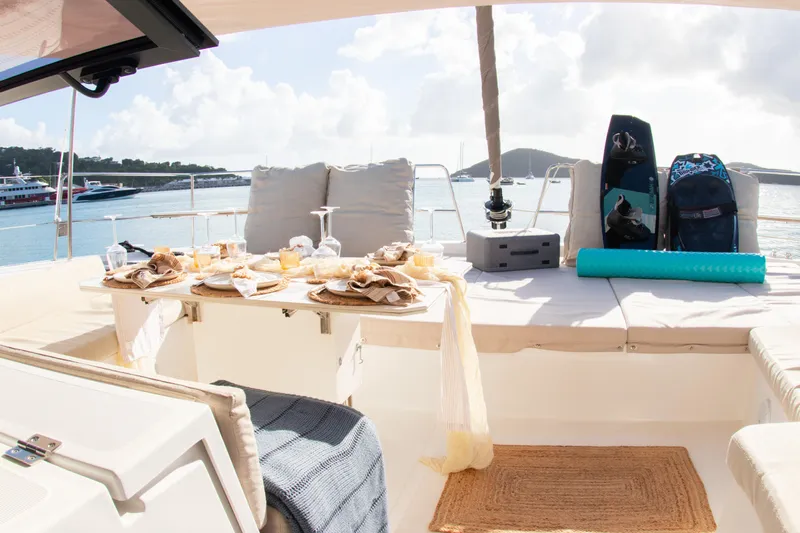  Yacht Photos Pics Luxurious Bali 4.8 catamaran deck with dining setup, paddleboards, and scenic ocean view.