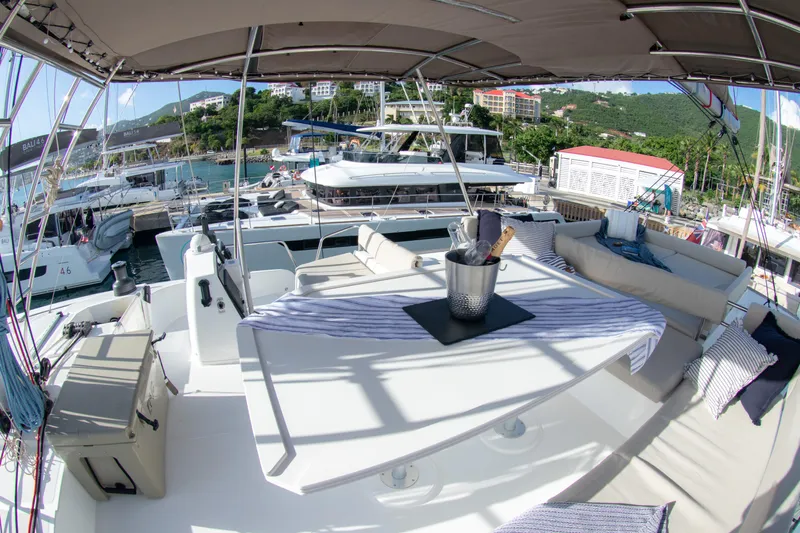  Yacht Photos Pics Luxurious Bali 4.8 yacht deck with seating, table, and champagne bucket, docked at marina.