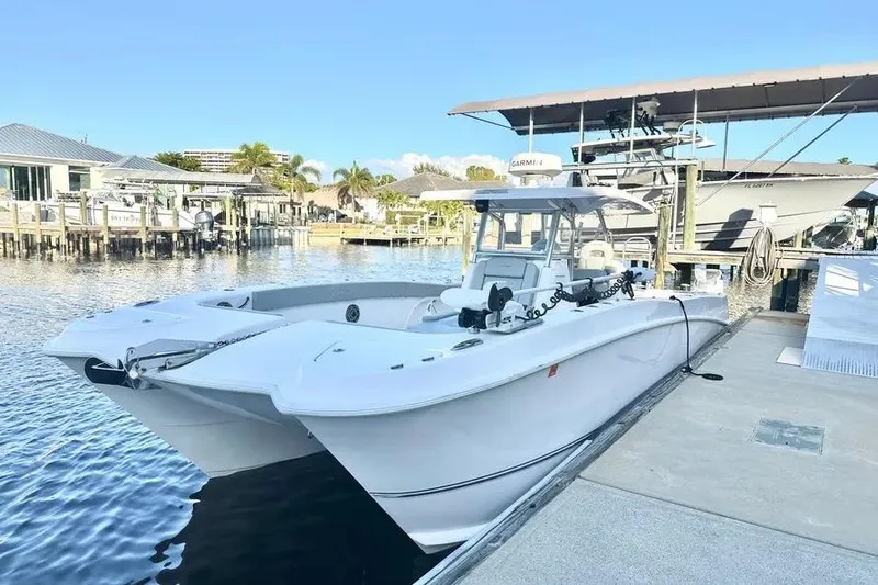  Yacht Photos Pics 2023 Twin Vee 340 GFX CC catamaran docked at a marina under clear blue skies.