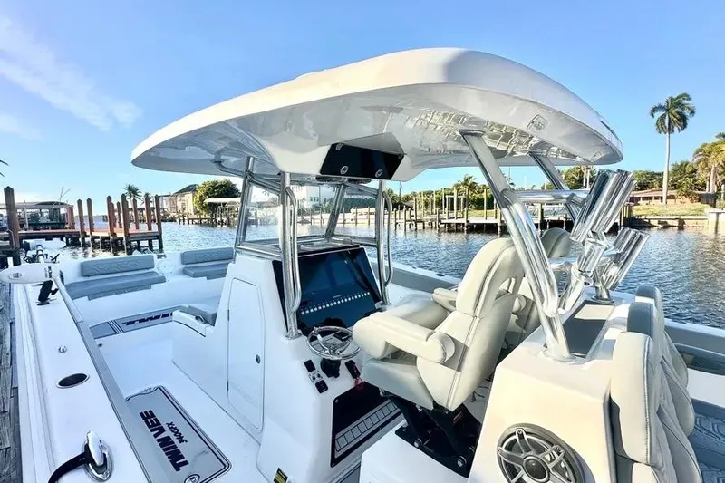  Yacht Photos Pics 2023 Twin Vee 340 GFX CC boat interior with helm, seats, and rod holders by the dock.