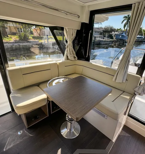  Yacht Photos Pics 2025 Wellcraft 355 yacht interior with elegant seating and table, featuring large windows and scenic views.