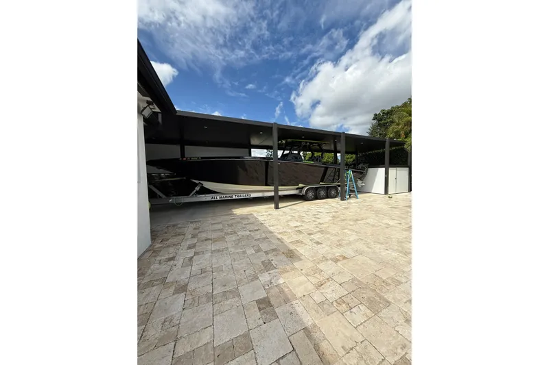  Yacht Photos Pics 2006 Fountain 38 CC Tournament Edition boat on trailer under shelter, sunny day.