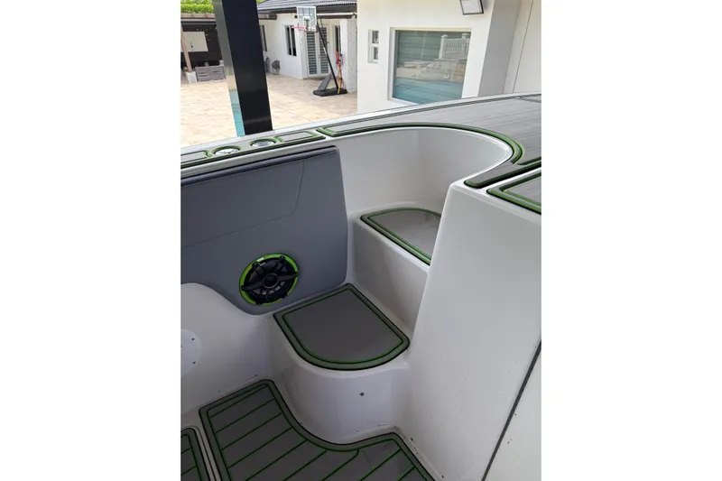  Yacht Photos Pics 2006 Fountain 38 CC Tournament Edition boat interior with green-trimmed seating and speaker.