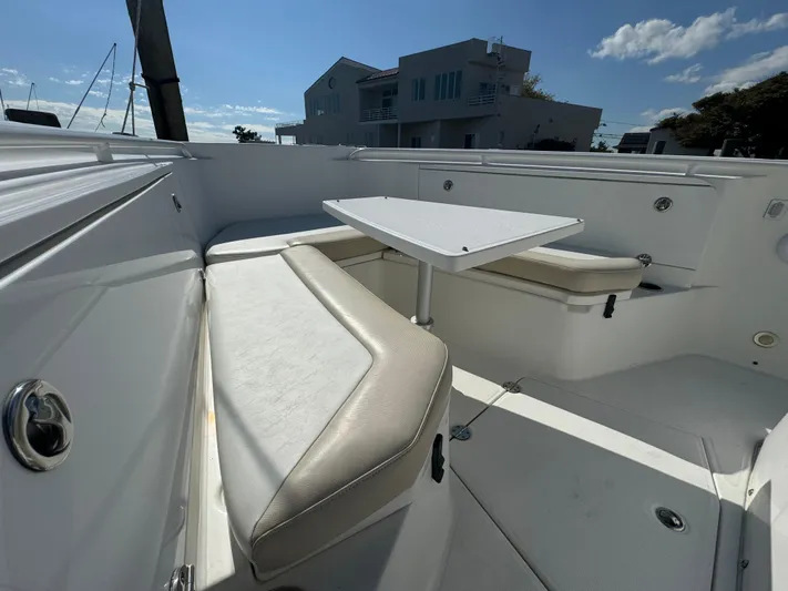  Yacht Photos Pics 2011 Everglades 325 Center Console boat interior with seating and table, under clear sky.