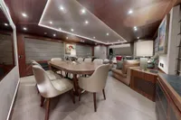 Luxurious interior of 2018 Benetti 95 Delfino yacht with elegant dining area and modern lighting.