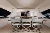 Luxurious 2018 Benetti 95 Delfino yacht deck with elegant dining area at night.