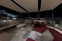 Luxurious outdoor seating on 2018 Benetti 95 Delfino yacht at night.