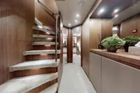 Luxurious interior of 2018 Benetti 95 Delfino yacht with modern wooden staircase and elegant decor.
