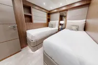 Luxurious twin bedroom on 2018 Benetti 95 Delfino yacht, featuring modern design and elegant finishes.