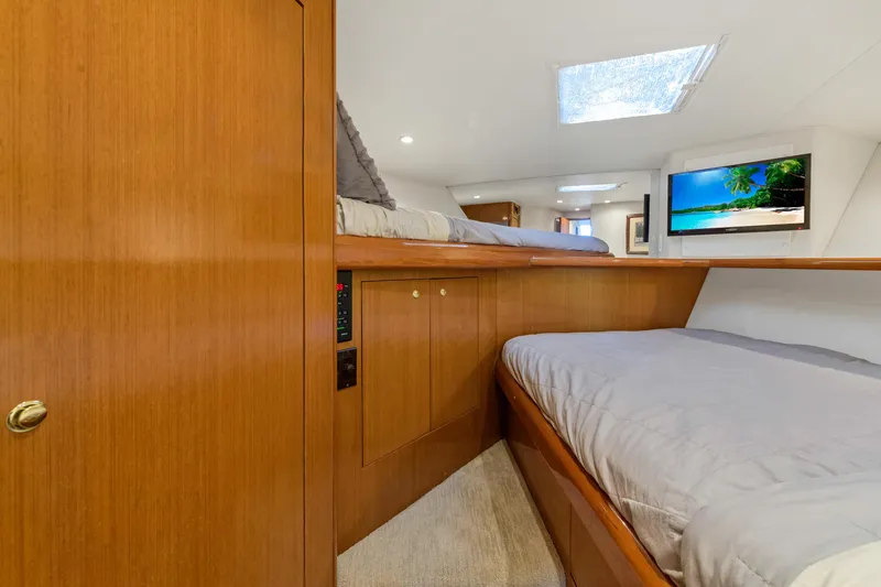  Yacht Photos Pics Interior cabin of 2001 Viking 55 Convertible yacht with wooden finishes and cozy bedding.