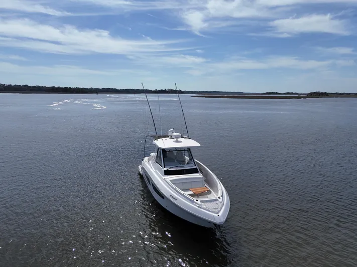  Yacht Photos Pics 2020 Regal 33 SAV boat on calm water under a clear blue sky.