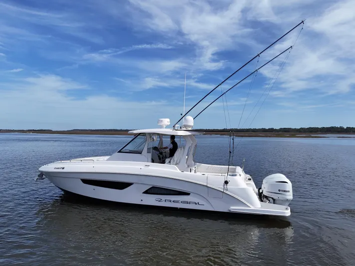  Yacht Photos Pics 2020 Regal 33 SAV boat on calm water under a clear blue sky.