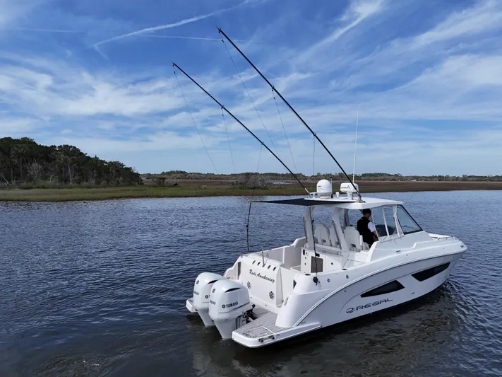  Yacht Photos Pics 2020 Regal 33 SAV boat on calm water with fishing rods, clear sky background.