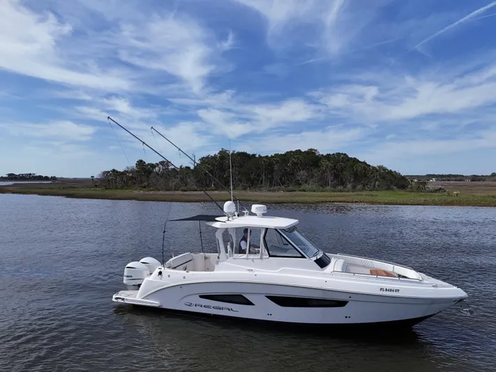  Yacht Photos Pics 2020 Regal 33 SAV boat on calm water with scenic background.