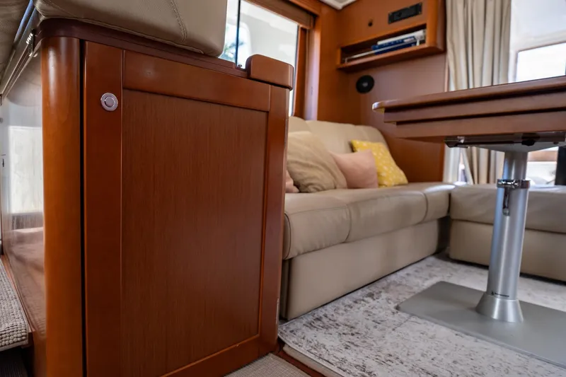 Wanderer Yacht Photos Pics Interior of 2016 Beneteau Swift Trawler 44 with beige sofa and wooden table.