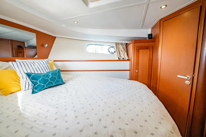 Wanderer Yacht Photos Pics 2016 Beneteau Swift Trawler 44 cabin with cozy bed and colorful pillows.