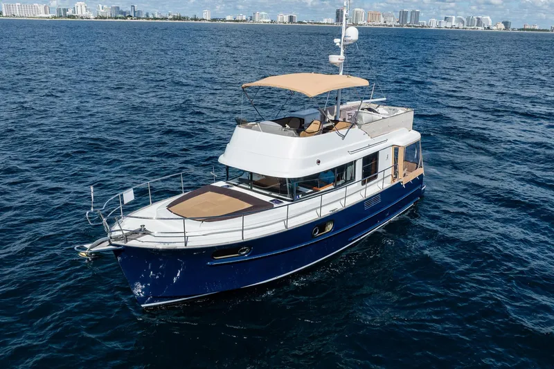Wanderer Yacht Photos Pics 2016 Beneteau Swift Trawler 44 cruising on open water with city skyline in background.