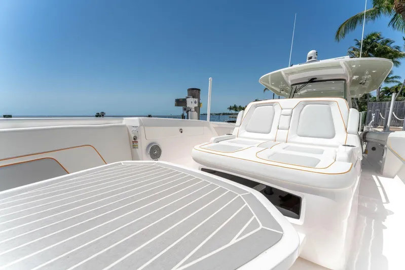  Yacht Photos Pics 2021 Intrepid 407 Panacea luxury boat interior with white seating and table, under clear blue sky.