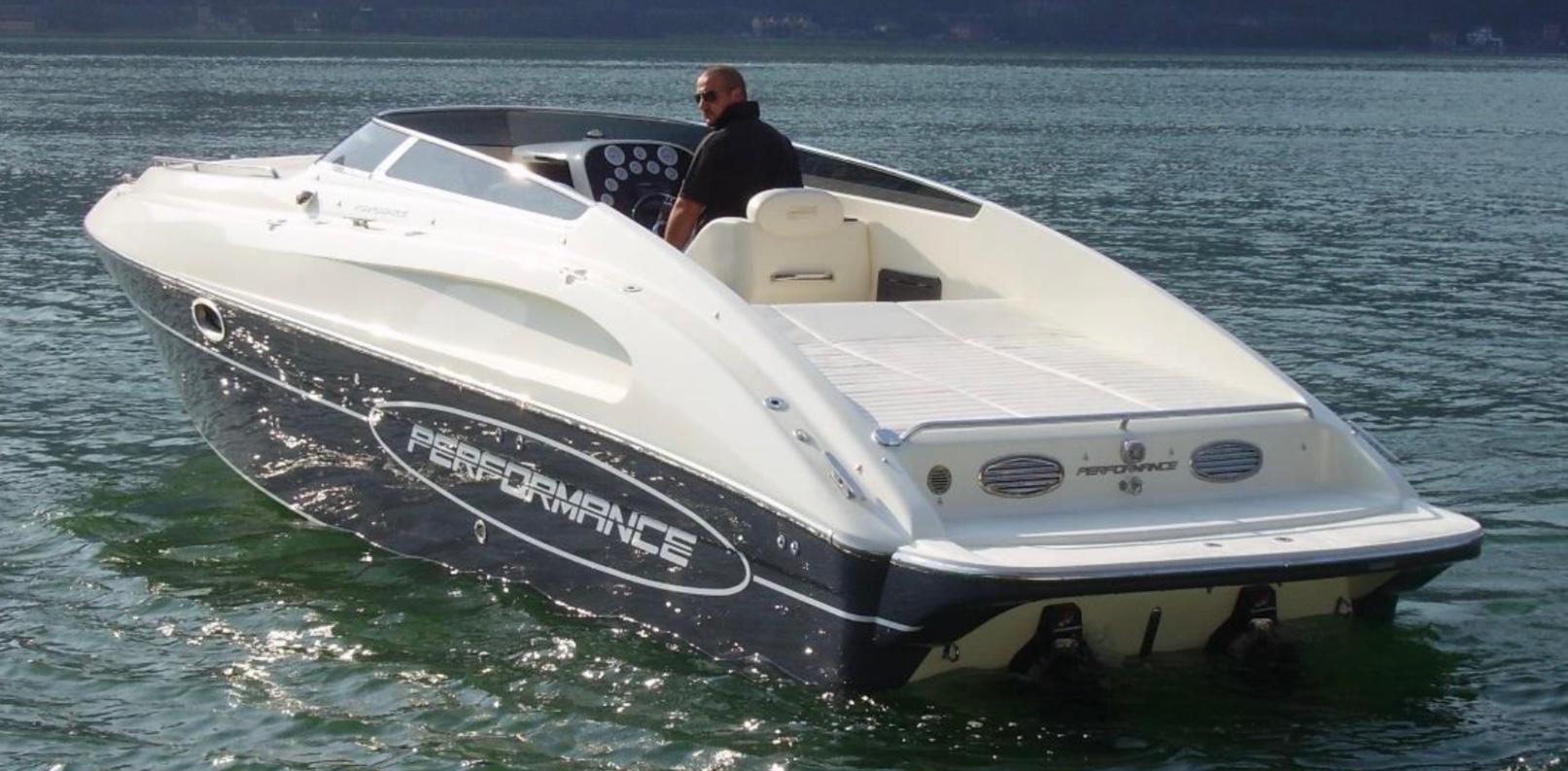 2009 Performance 807 speedboat cruising on a calm lake with a person at the helm.