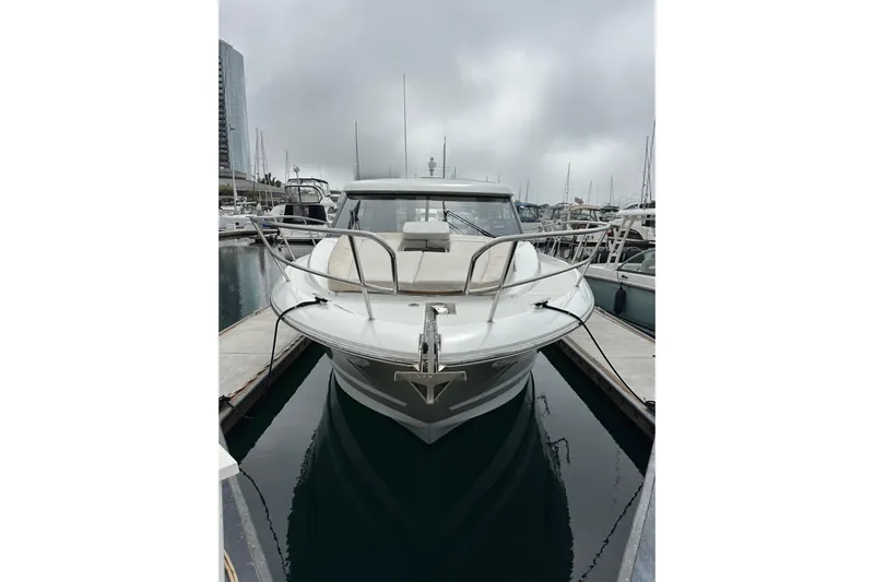  Yacht Photos Pics 2015 Jeanneau NC11 boat docked in a marina on a cloudy day.