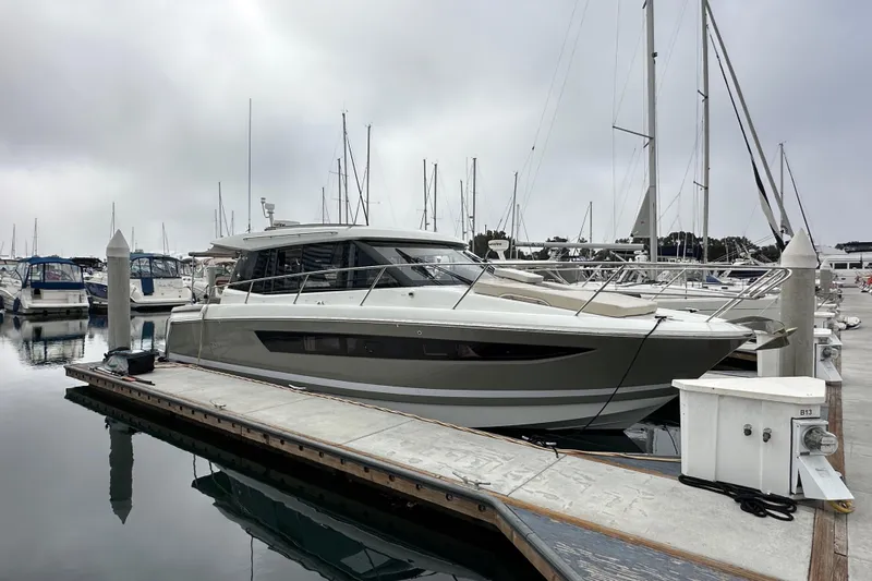  Yacht Photos Pics 2015 Jeanneau NC11 yacht docked at marina, surrounded by other boats.