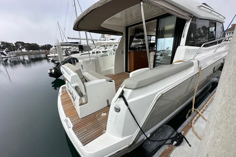  Yacht Photos Pics 2015 Jeanneau NC11 yacht docked at marina, showcasing sleek design and spacious deck.