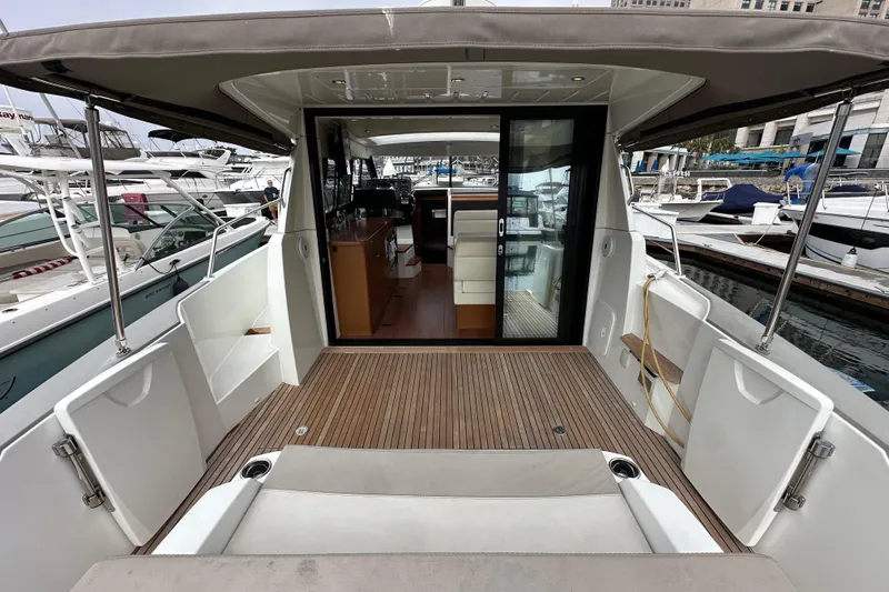  Yacht Photos Pics 2015 Jeanneau NC11 yacht with open deck and sliding glass doors at marina.