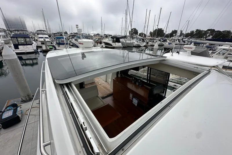  Yacht Photos Pics 2015 Jeanneau NC11 yacht with open sunroof, docked in a marina.