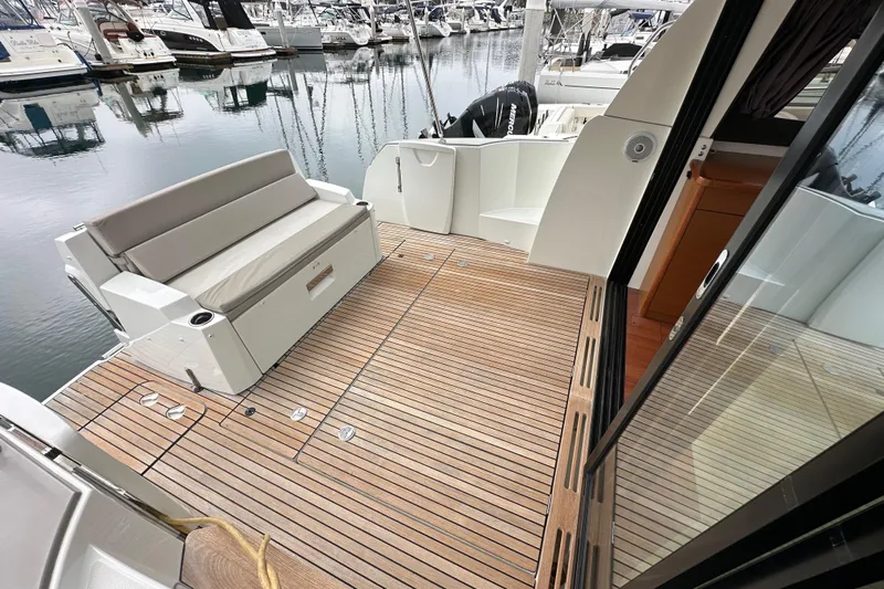 Yacht Photos Pics 2015 Jeanneau NC11 yacht with teak deck and seating at marina.