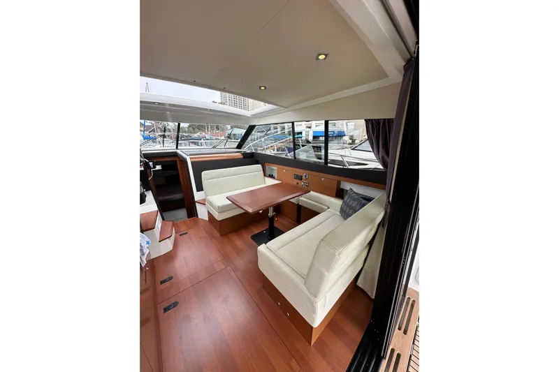  Yacht Photos Pics 2015 Jeanneau NC11 yacht interior with elegant seating and wooden flooring.